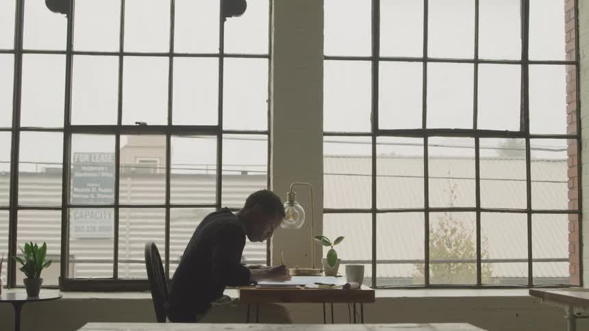 The office worker is writing at his desk