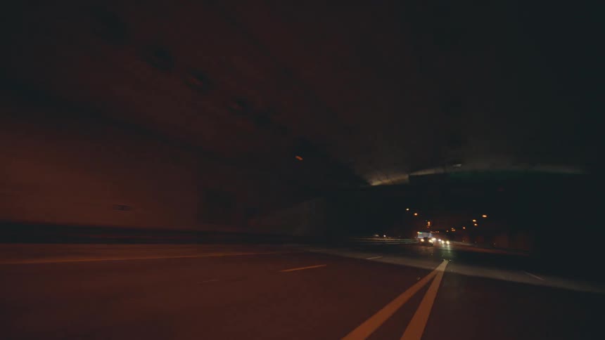 Cars are driving through a tunnel on a highway