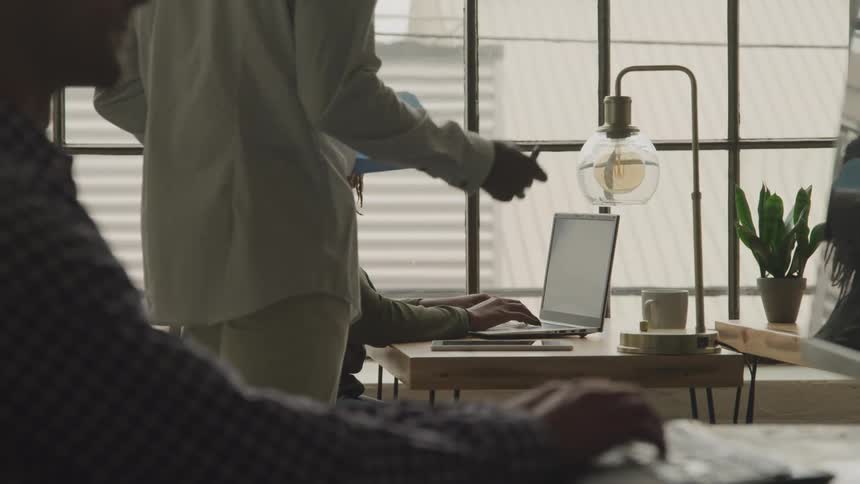 Business people work on laptops and computers in an office