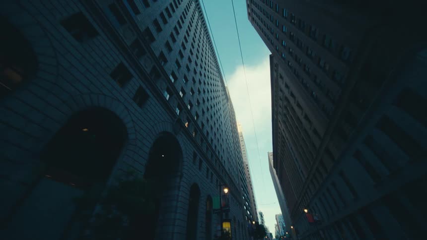Two tall buildings framing a narrow street with a glimpse of the sky above