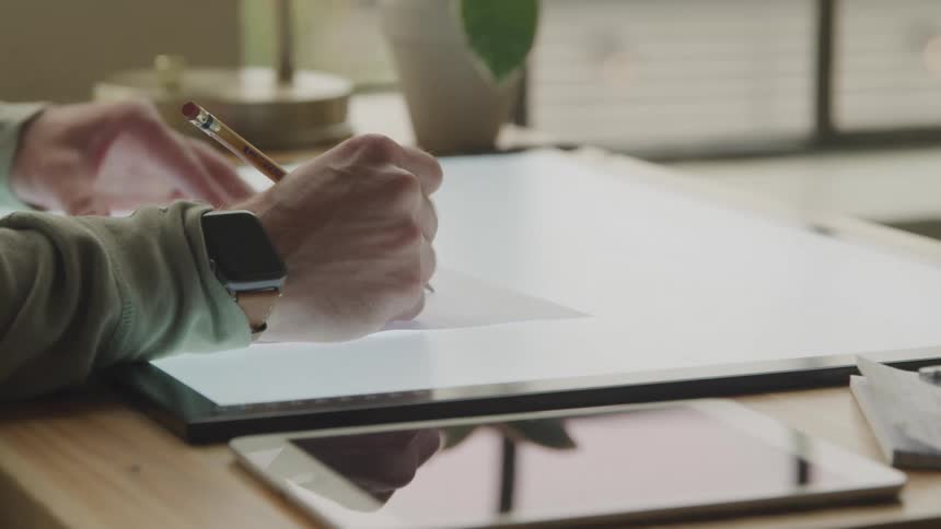 A worker writes with a pencil in the office