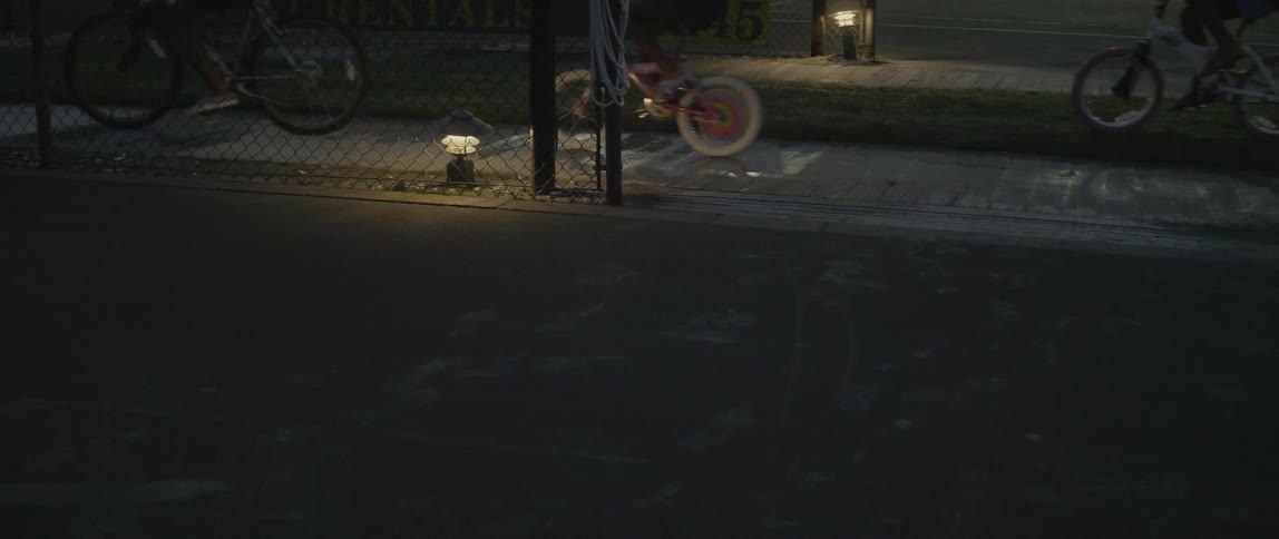 People riding bicycles ride down a sidewalk