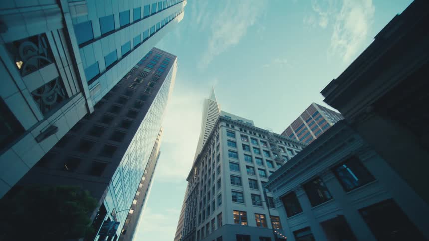 Skyscrapers tower over a city street on a cloudy day