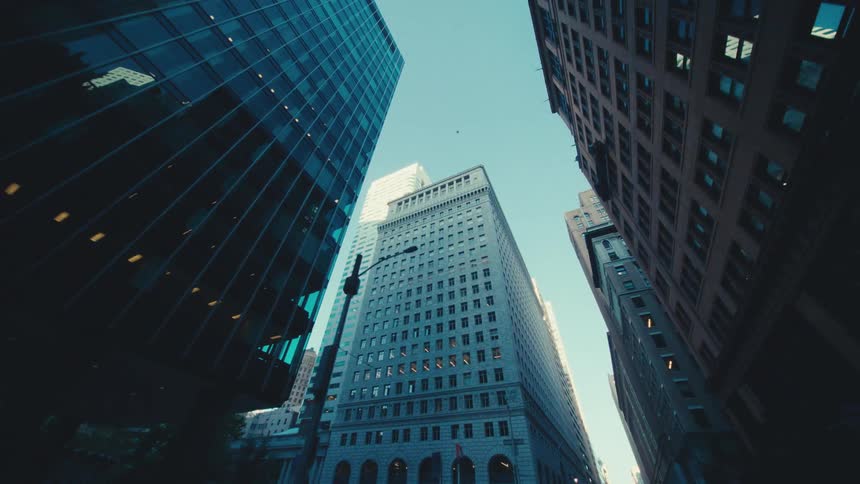 Tall buildings against a clear sky emphasizing their architectural diversity and the narrow space between them