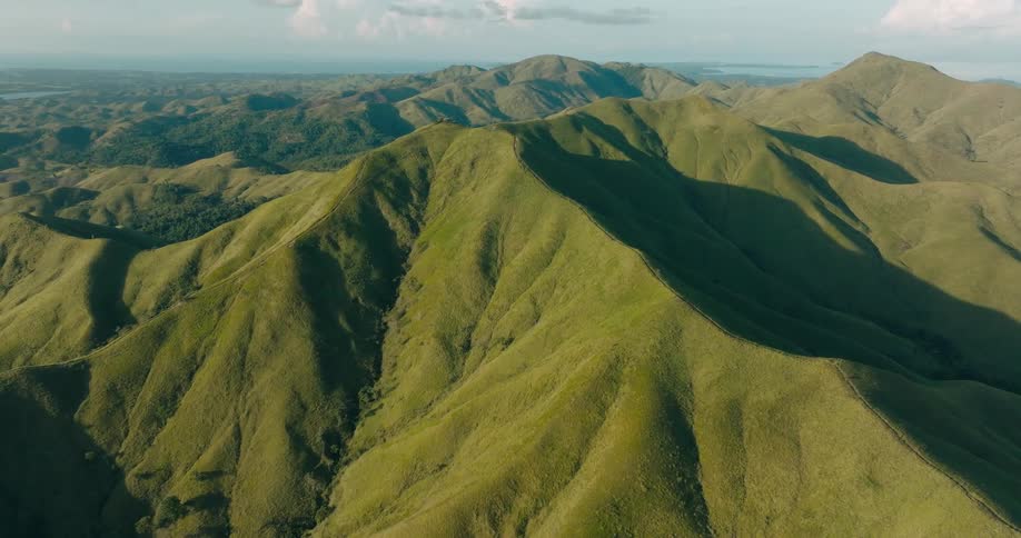 Trees fill crevices and valleys in mountainous terrain on a cloudy day