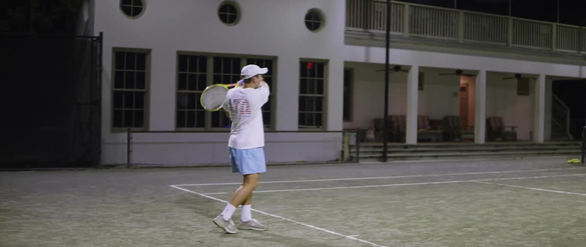 A man hits a tennis ball back on a tennis court