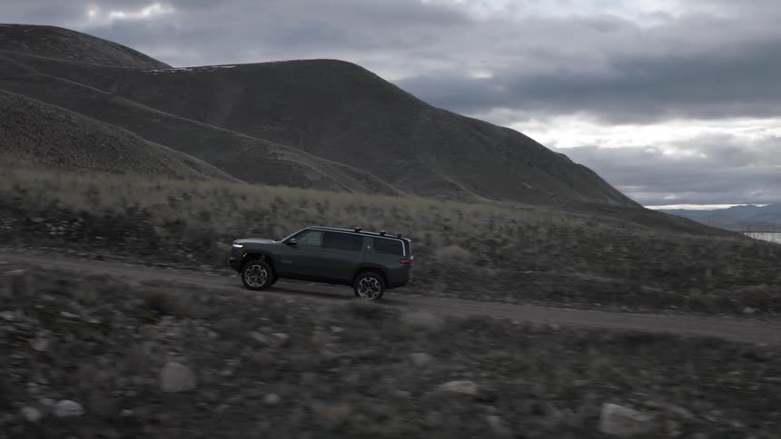 A person driving a car uphill near the coast of a body of water