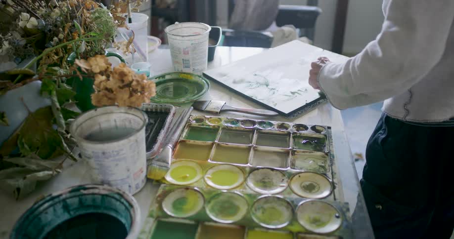 Man brushing a canvas over a table
