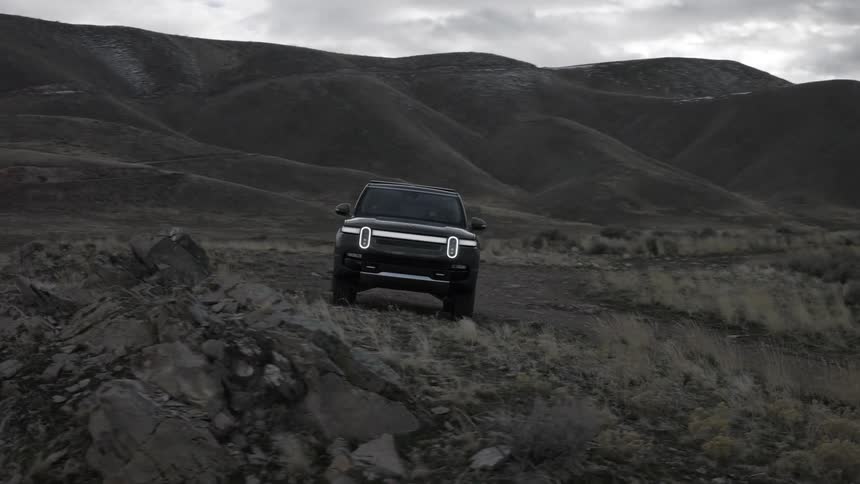 A vehicle is parked in front of the mountain