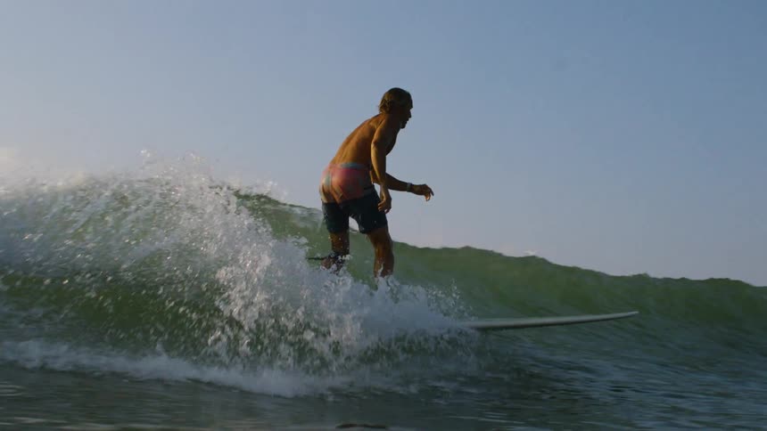 A surfer rides along a small wave