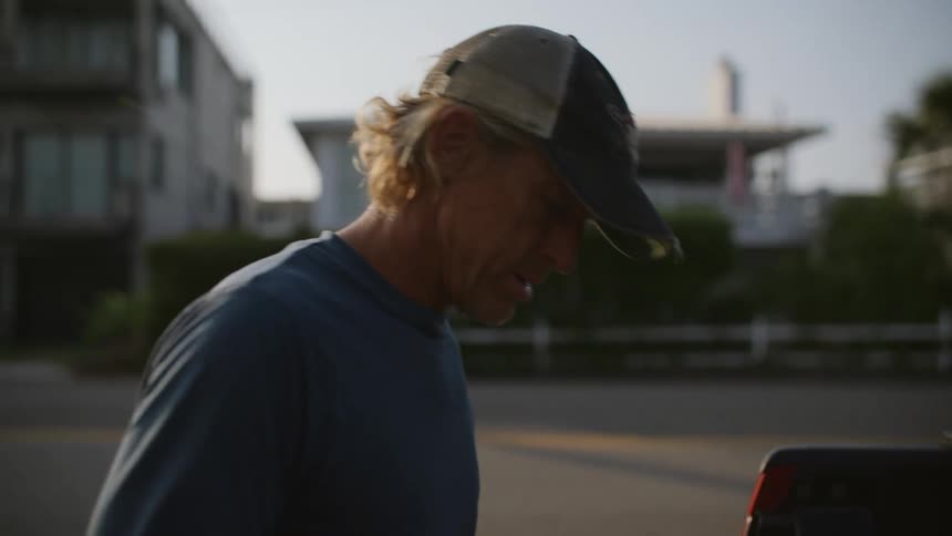 A man is looking through the back of his truck