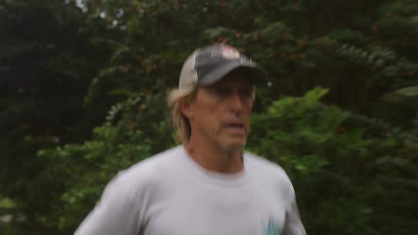 A man jogging past trees