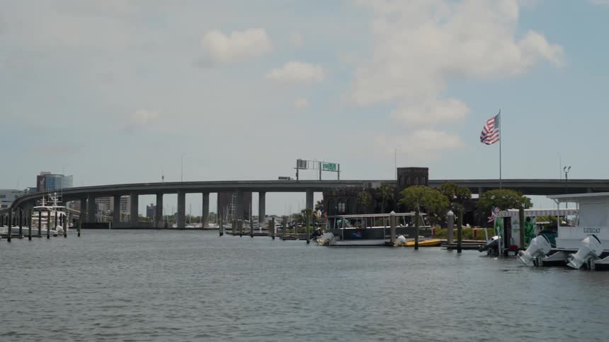View from a harbor with docked ships and a bridge with a busy street