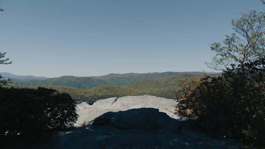 Shadows partially cover a patch of white in the hills bordering the mountains