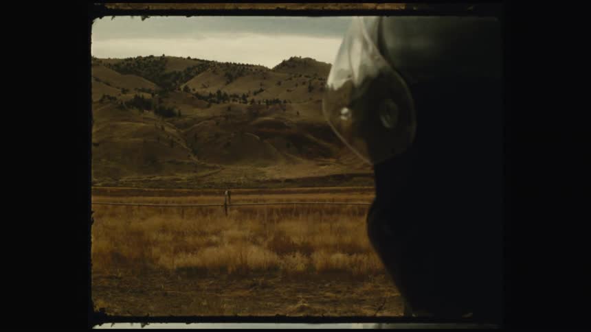 A footage of a person wearing an helmet standing close to the mountainous area