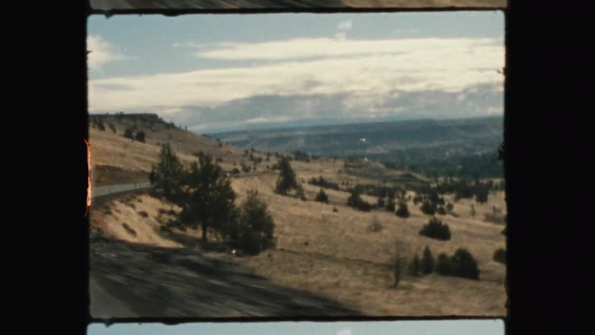 The road is on the side of a hill by a mountain
