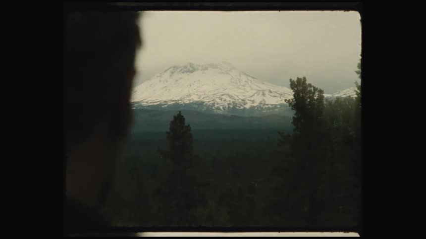 A man is looking towards the mountain in the distance