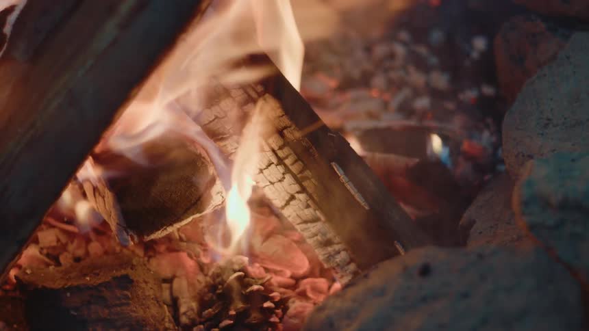 Close up of flickering flames burning the wood of a campfire
