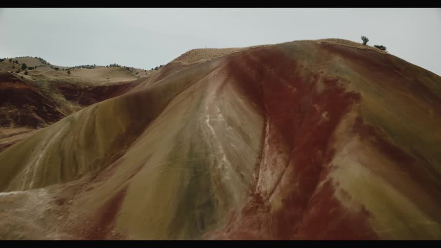 Aerial drone view of a flight over hills and scarce vegetation in a desert area
