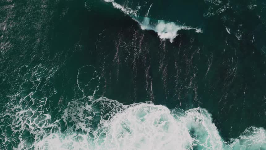 A gigantic wave crashes in the middle of the ocean