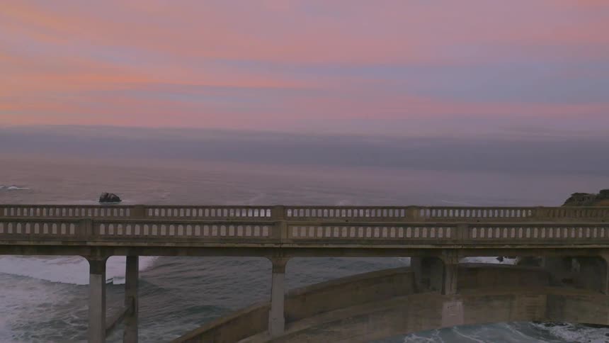 The water below this tall bridge is very rough at dawn