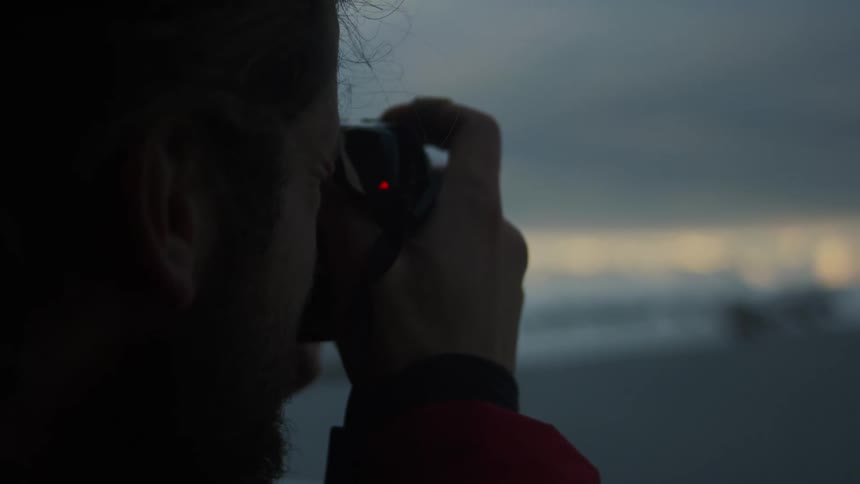 Man takes a picture while outdoors on an overcast day