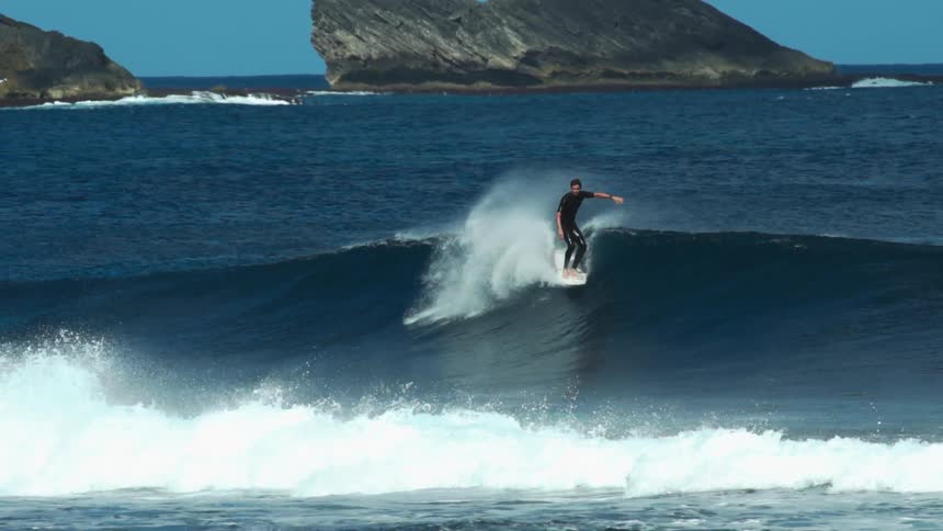 A man surfs the wave by the shore
