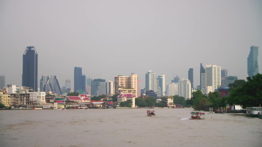 Boats travel in the water by the city