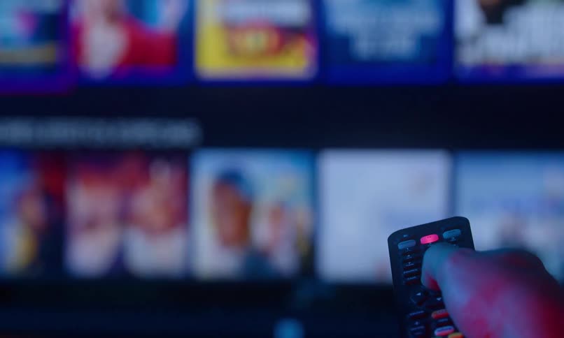 A mans hand flipping through tv channels fast using a remote