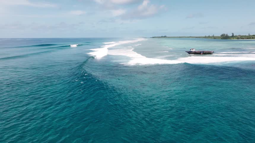 Waves travel towards the boat headed to sea