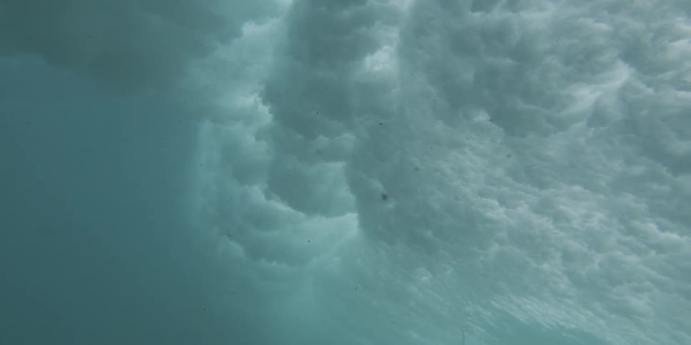 The swirling patterns and textures of a powerful wave creating a sense of dramatic movement and depth