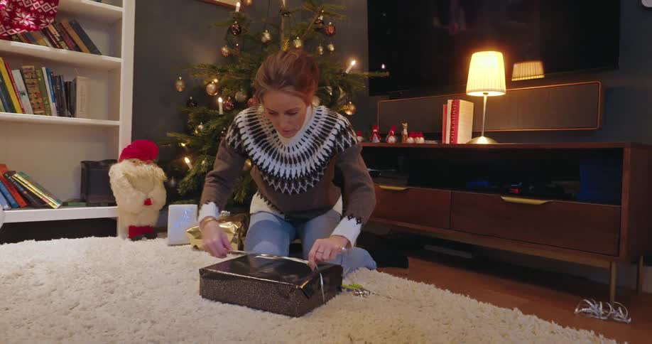 A woman is wrapping a christmas gift