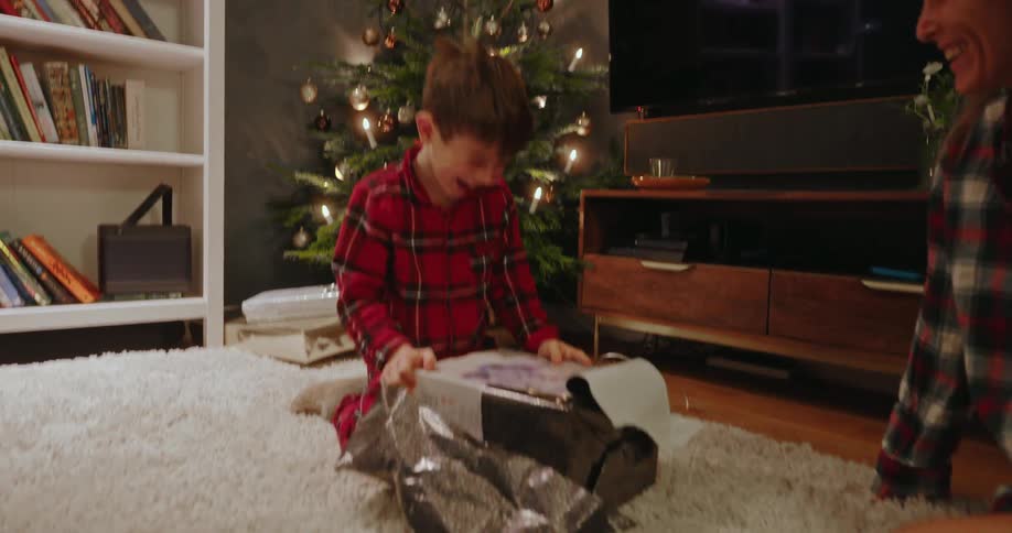A child is very happy while opening a christmas gift