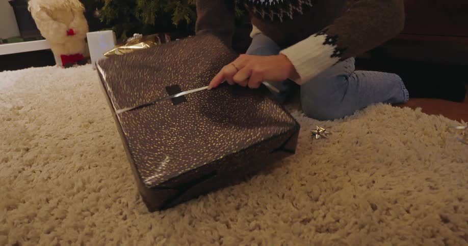 A woman wraps the string around the present