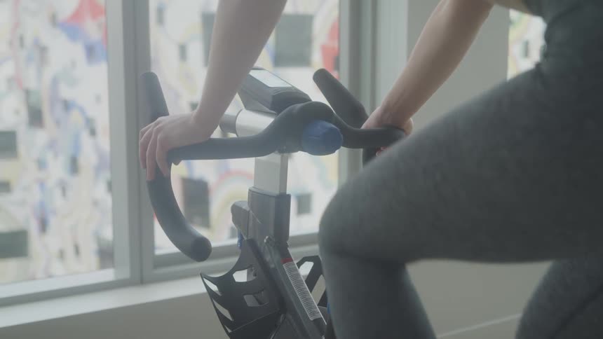 A footage of a lady exercising on a cardio machine