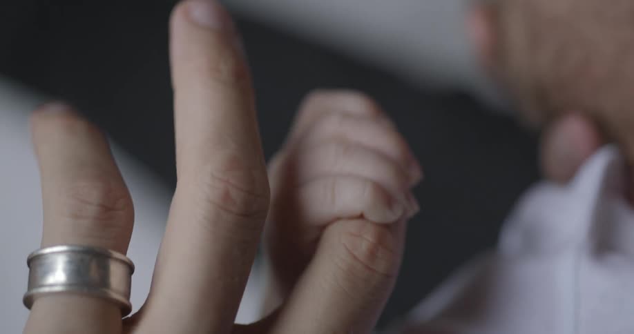 A man holds a baby's hand