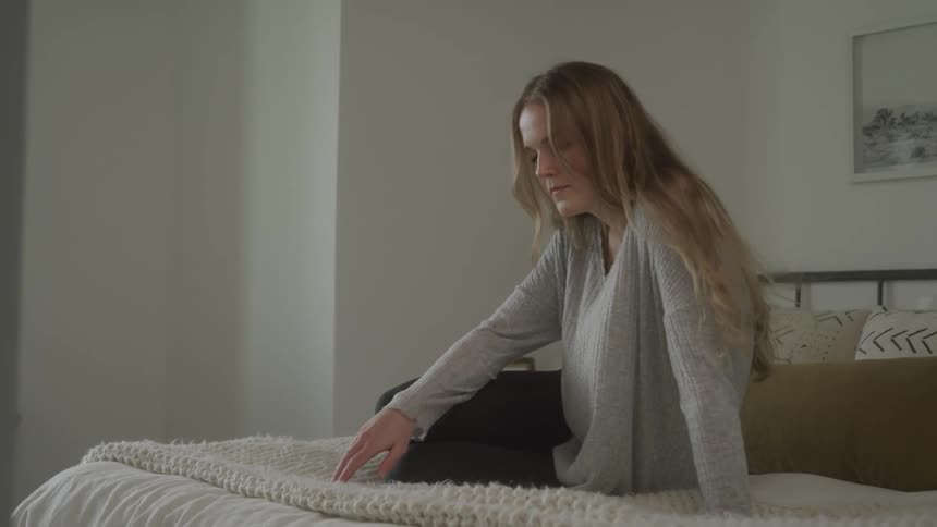A woman sits on the bed