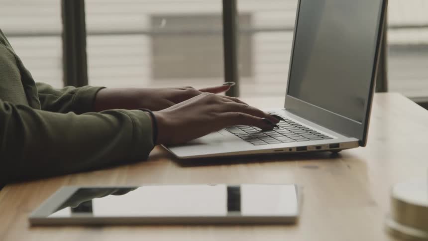 A woman types on her keyboard at the desk