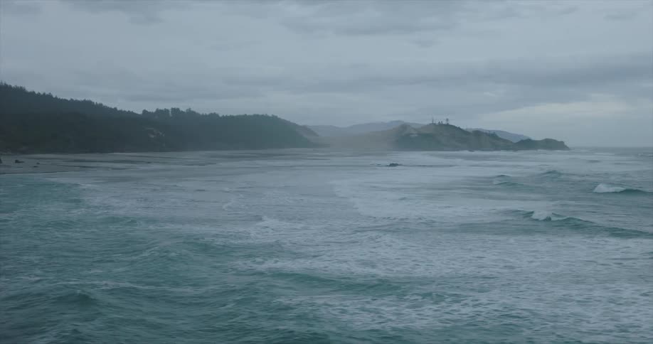 Fog covers a forested shore on an overcast day