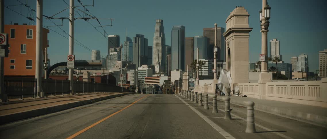 A desolate empty los angeles cityscape viewed from an elevated bridge during daylight