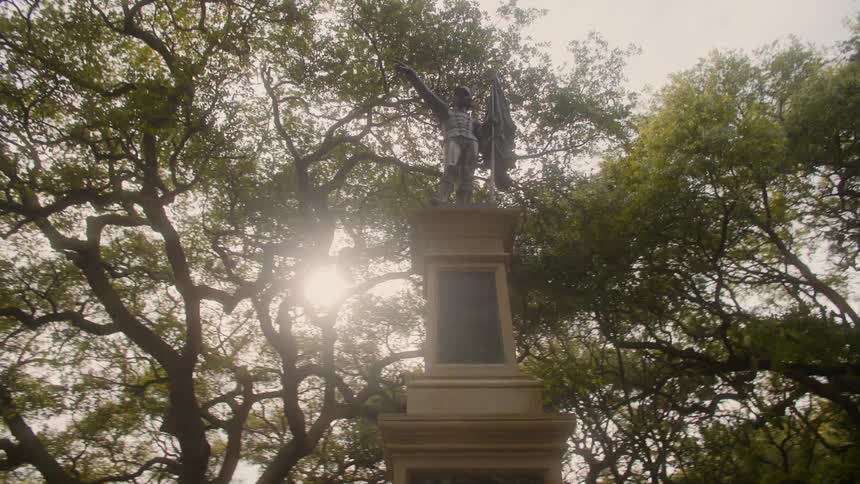 A large statue is surrounded by trees