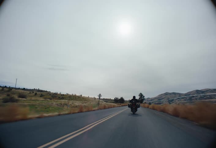 A person coasts down the highway on their motorcycle