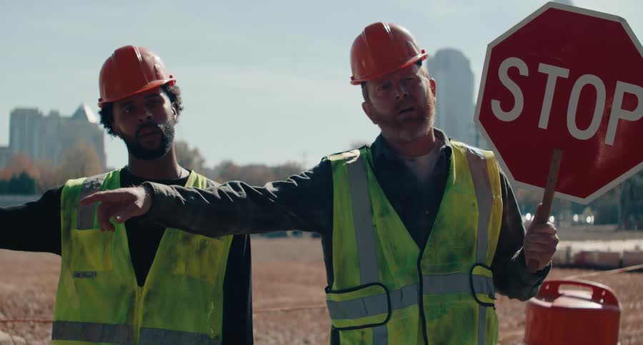 A footage of male workers holding a stop sign post