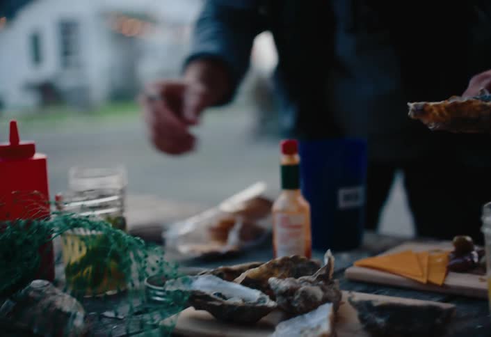 A man is eating clams outside