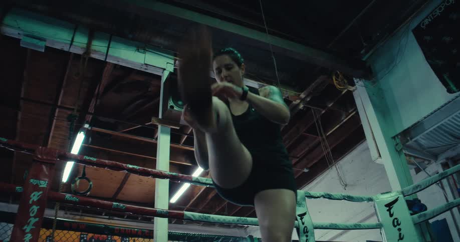 Inside an empty gym a woman is training by herself