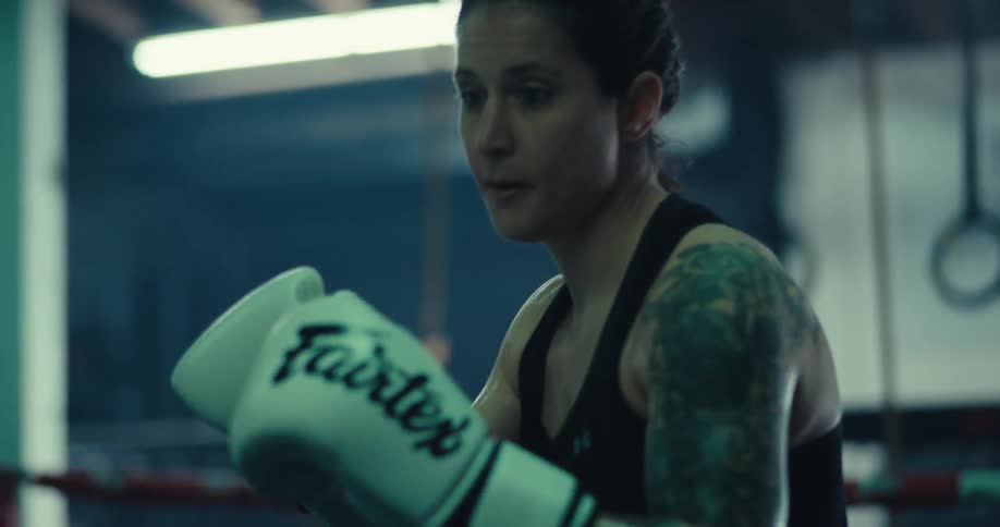 A woman is kicking and punching in the ring