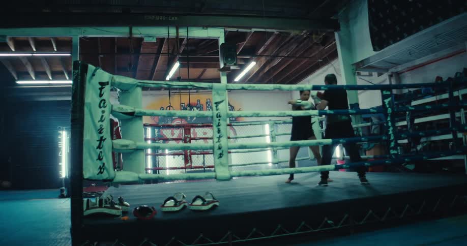 A man and a woman sparring in a boxing ring