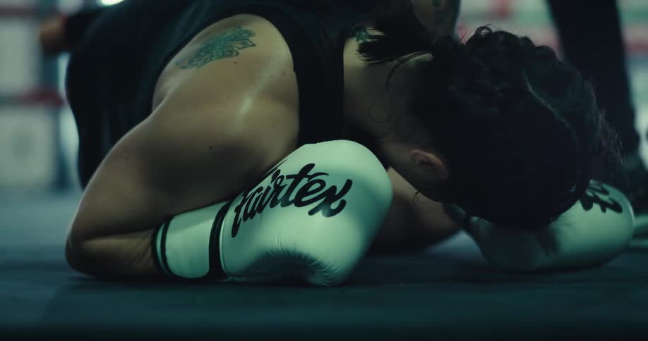 A boxer falls to the mat while sparring