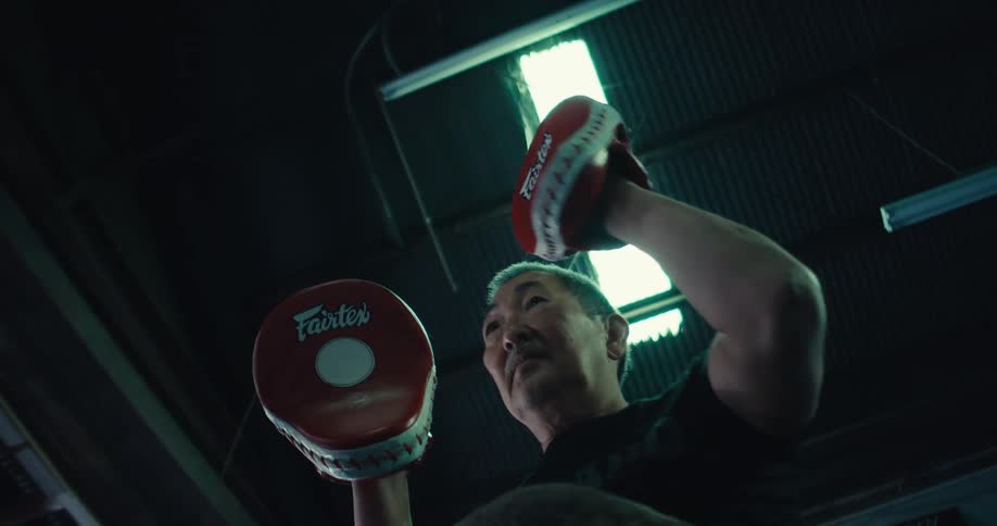 Gentleman coaching a boy in boxing