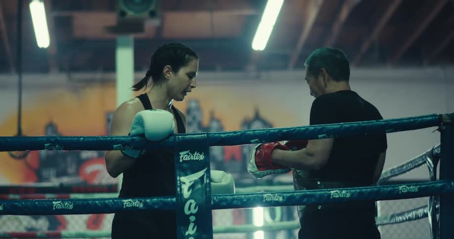 Two people are training together in a boxing ring